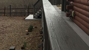 Une terrasse en bois offrant une vue sur les montagnes et un ciel nuageux.