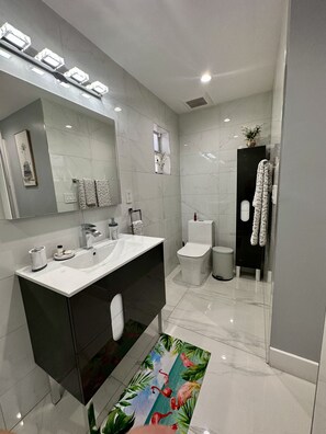 A modern bathroom with two sinks, a large mirror, and a black vanity. - Elegant beautiful house w/pool 10 min from Miami Int. Airport (Hialeah)