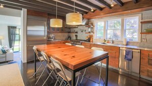 Una cucina moderna con isola in legno, elettrodomestici in acciaio inossidabile e ampie finestre.