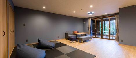 Una habitación moderna con zona de estar, una mesa y vistas al exterior.
