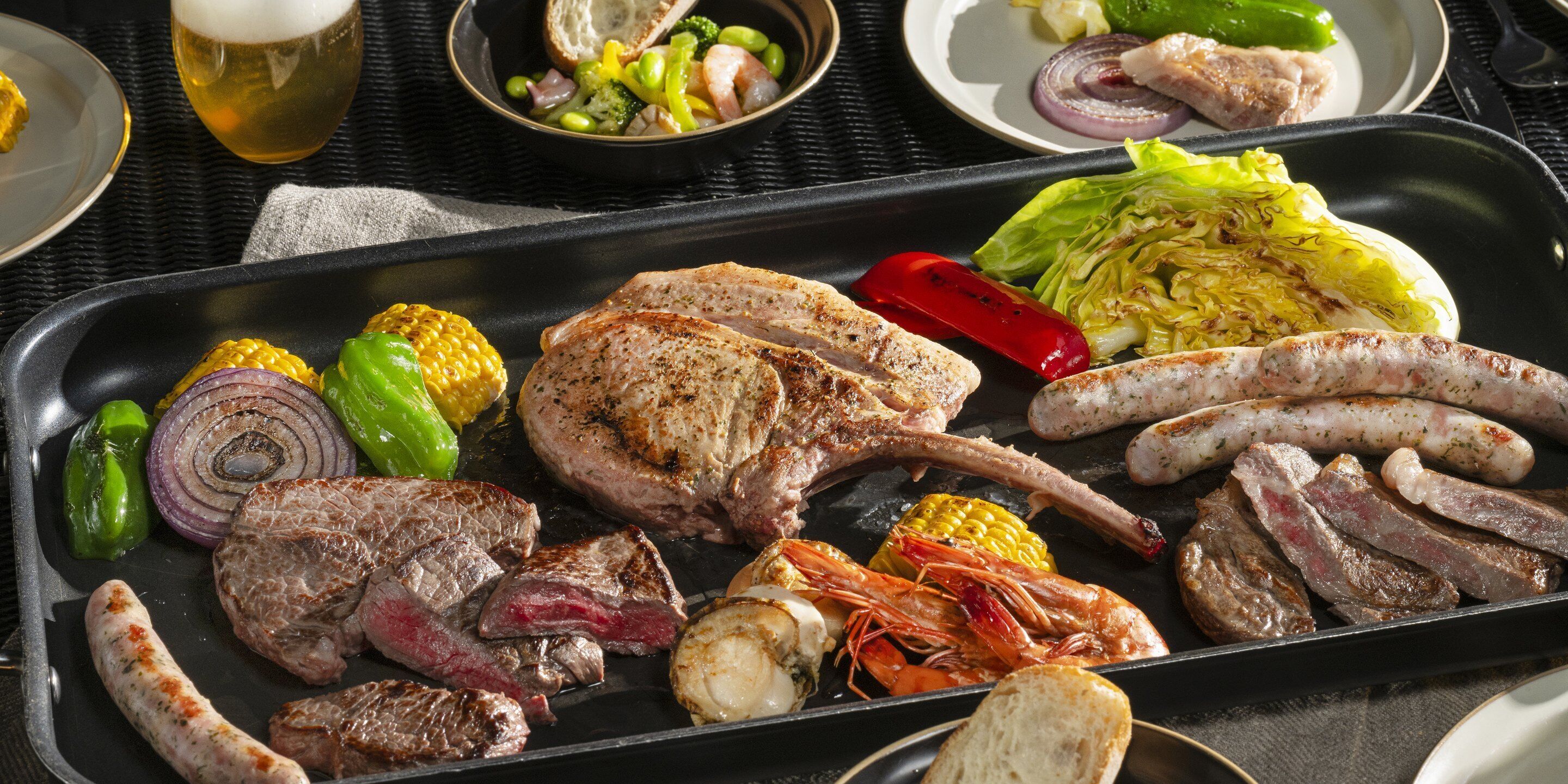 A grill with various meats and vegetables.