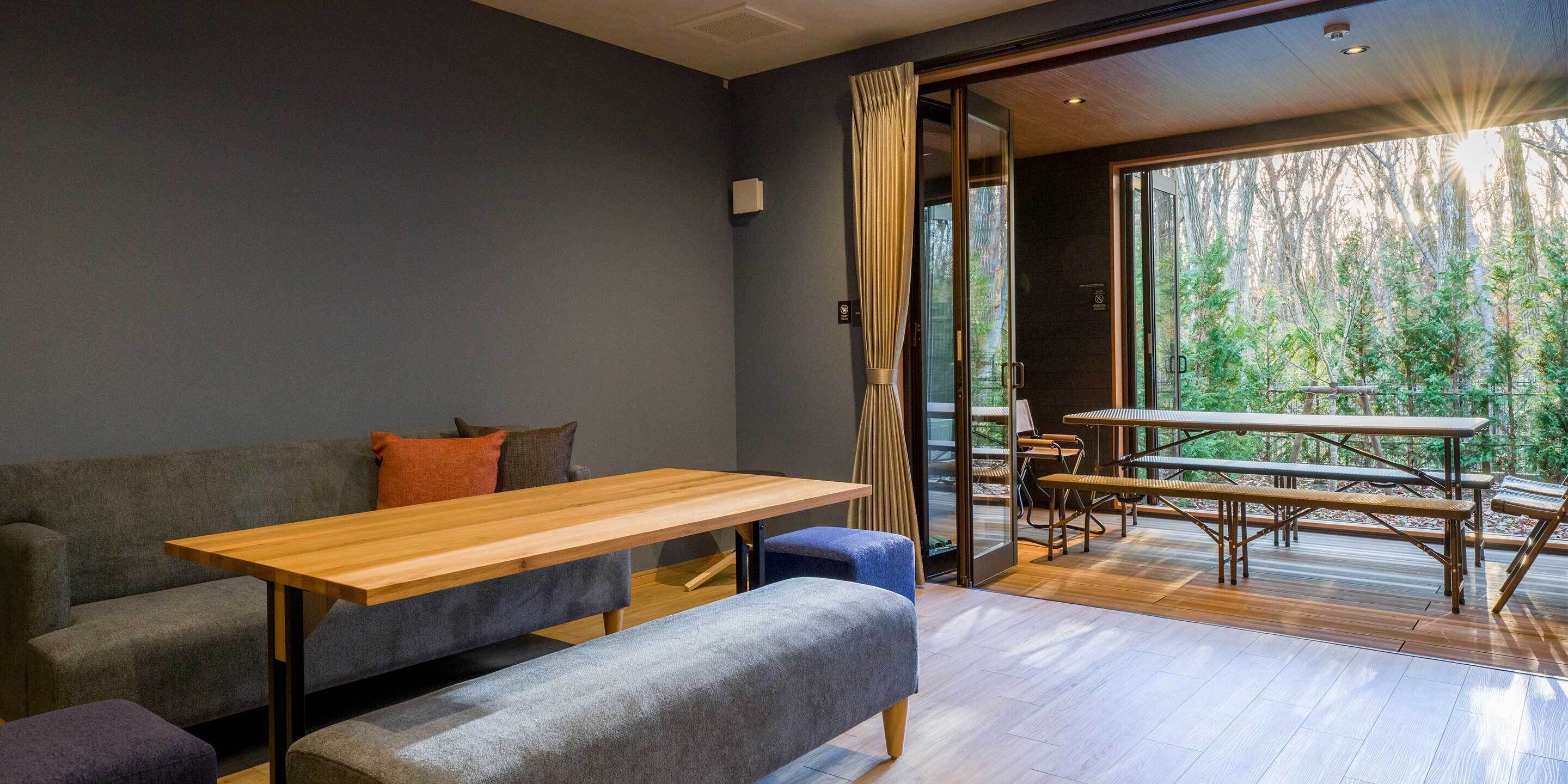 A modern interior with a sofa, a wooden table, and a bench.