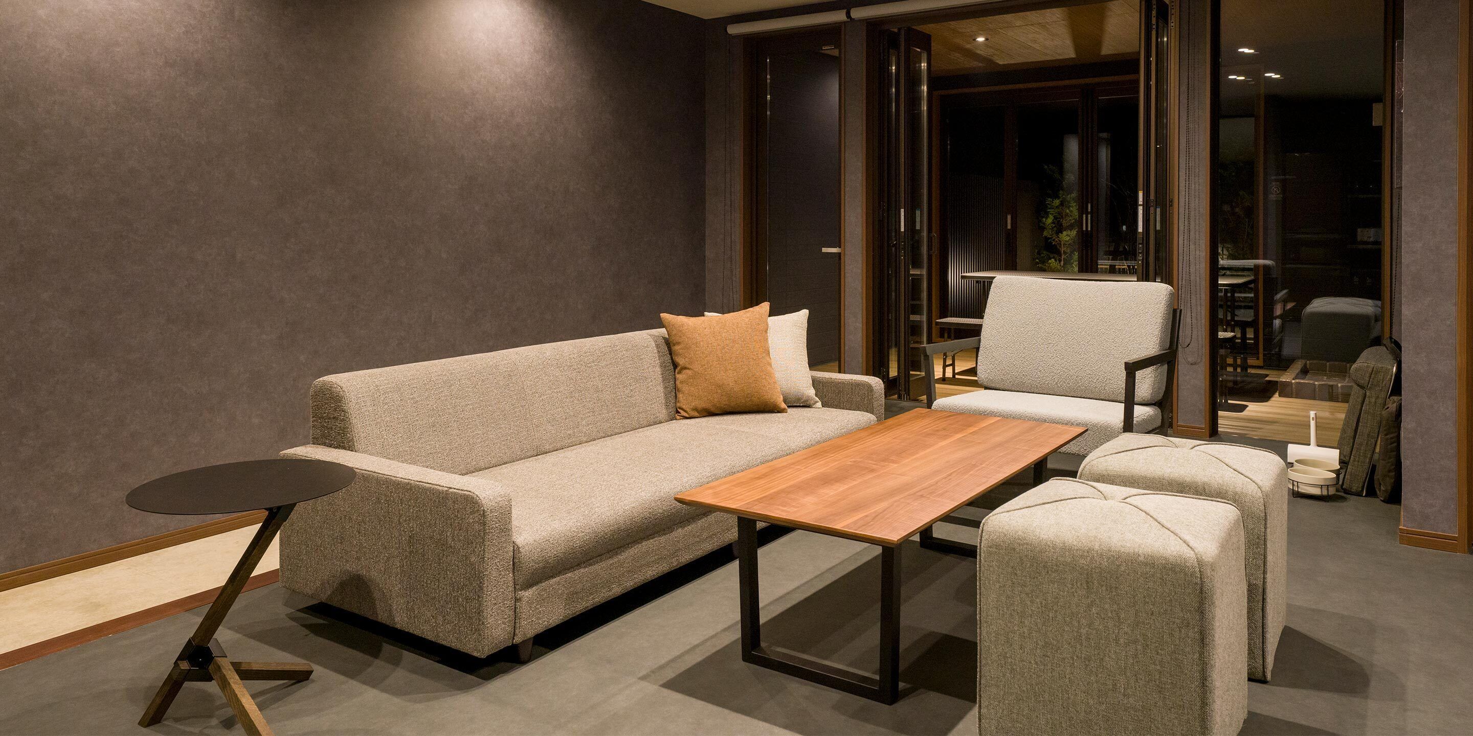 A modern living room with a sofa, a coffee table, and a chair.