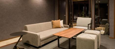 A modern living room with a sofa, a coffee table, and a chair.