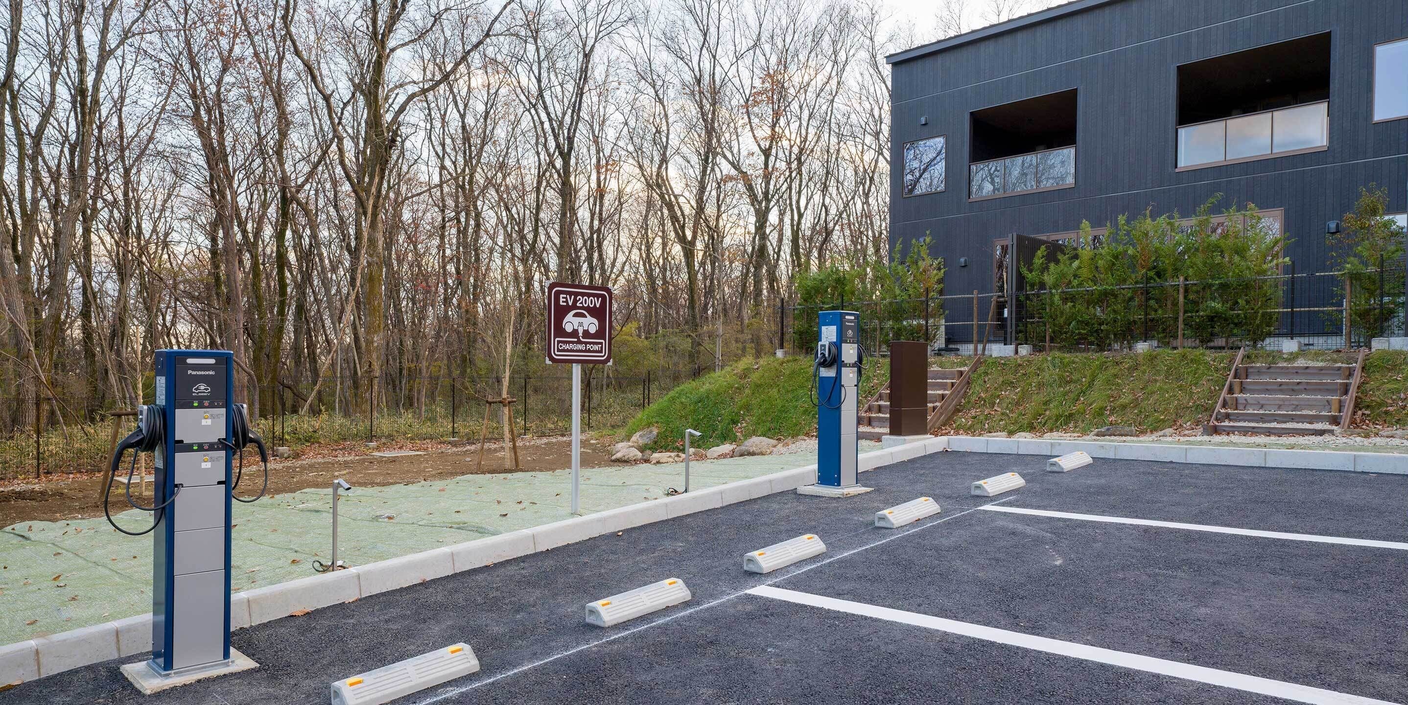 An EV charging station with a sign indicating it is a 200V charging point.
