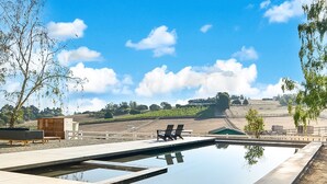 A swimming pool with lounge chairs and a view of a hilly landscape. - The Ranch, West Sonoma County (Sebastopol)