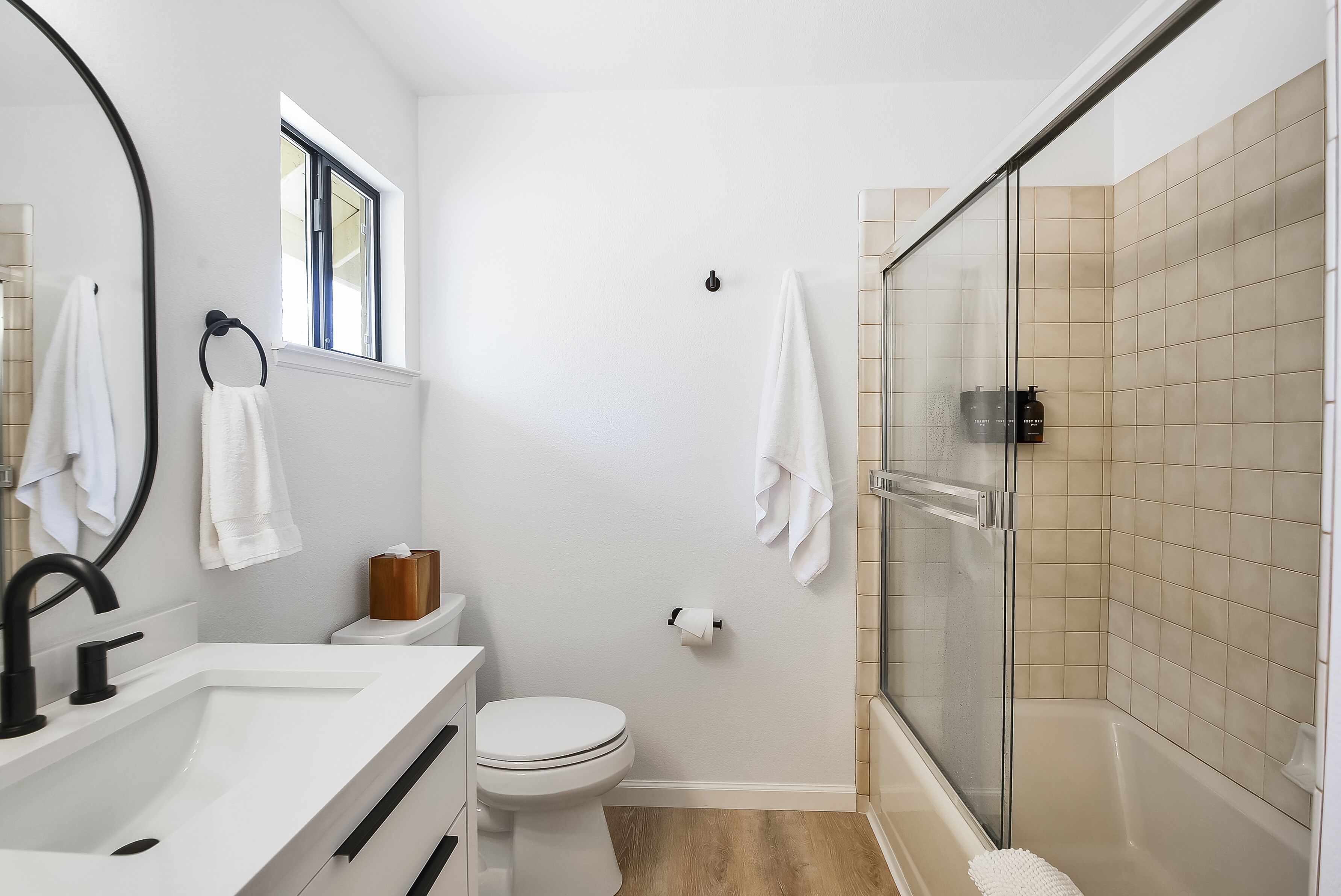 Une salle de bain moderne avec un lavabo, des toilettes et une zone de douche, le tout de couleur blanche.