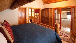 Une chambre avec un grand lit, des meubles en bois et une vue sur un balcon.