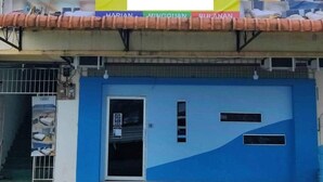 A hotel with a blue facade and a banner advertising 'CHEN ROOM BS' with room types listed. - OYO HOME 90667 Chen Room Bs (Semporna)
