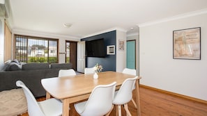 Relax in this stylish living space with a dining area, large window, and comfortable seating.