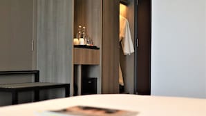 A hotel room with a bed, a nightstand, a shelf with toiletries, and a door leading to a bathroom. - KSL Esplanade Hotel (Teluk Panglima Garang)