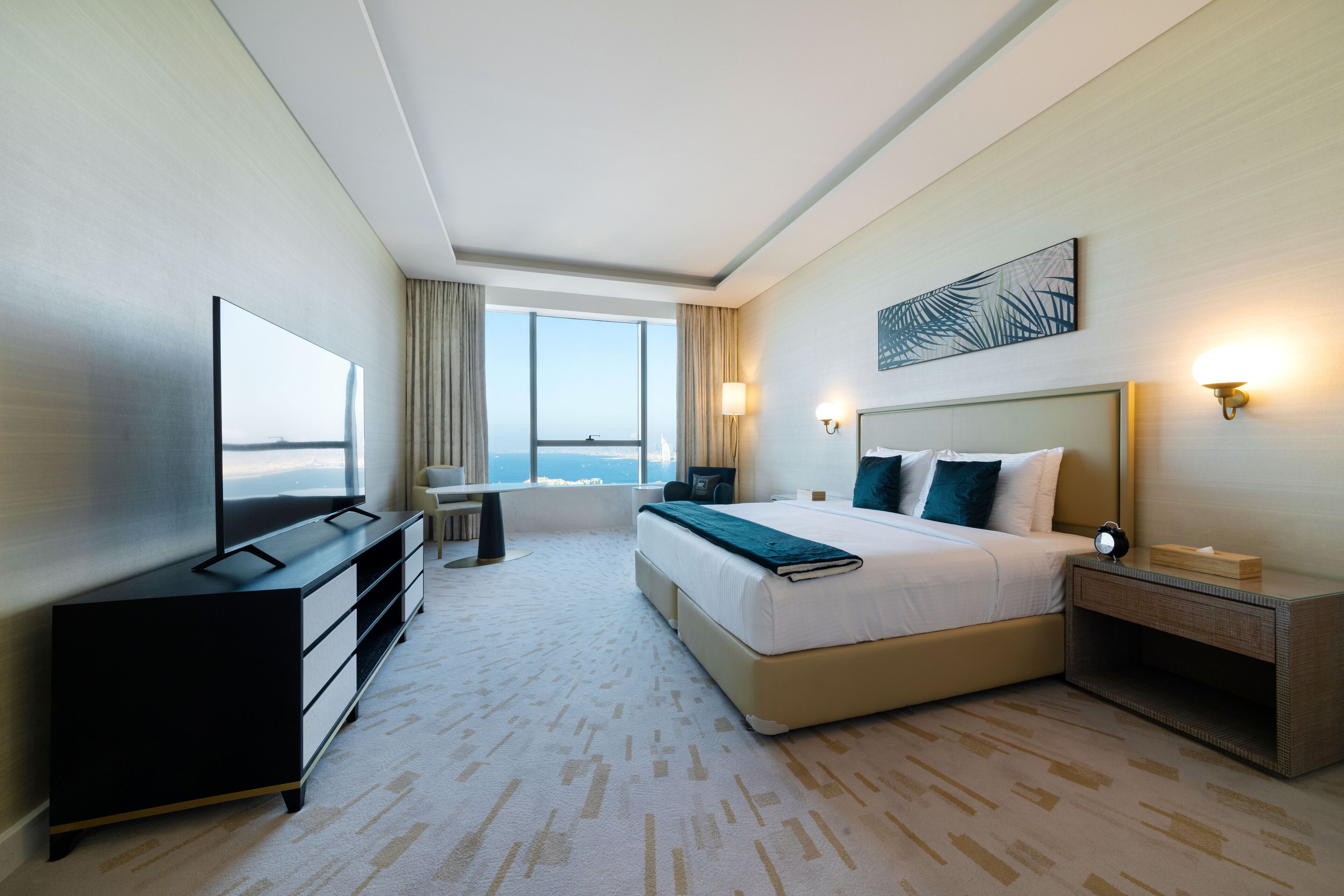 Habitación de hotel moderna con una cama grande, televisor de pantalla plana, escritorio y vistas a la ciudad.