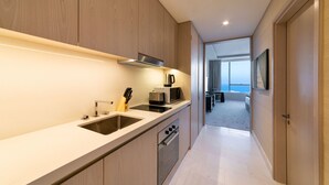 A modern kitchen with wooden cabinets, stainless steel appliances, and a view to the living area.