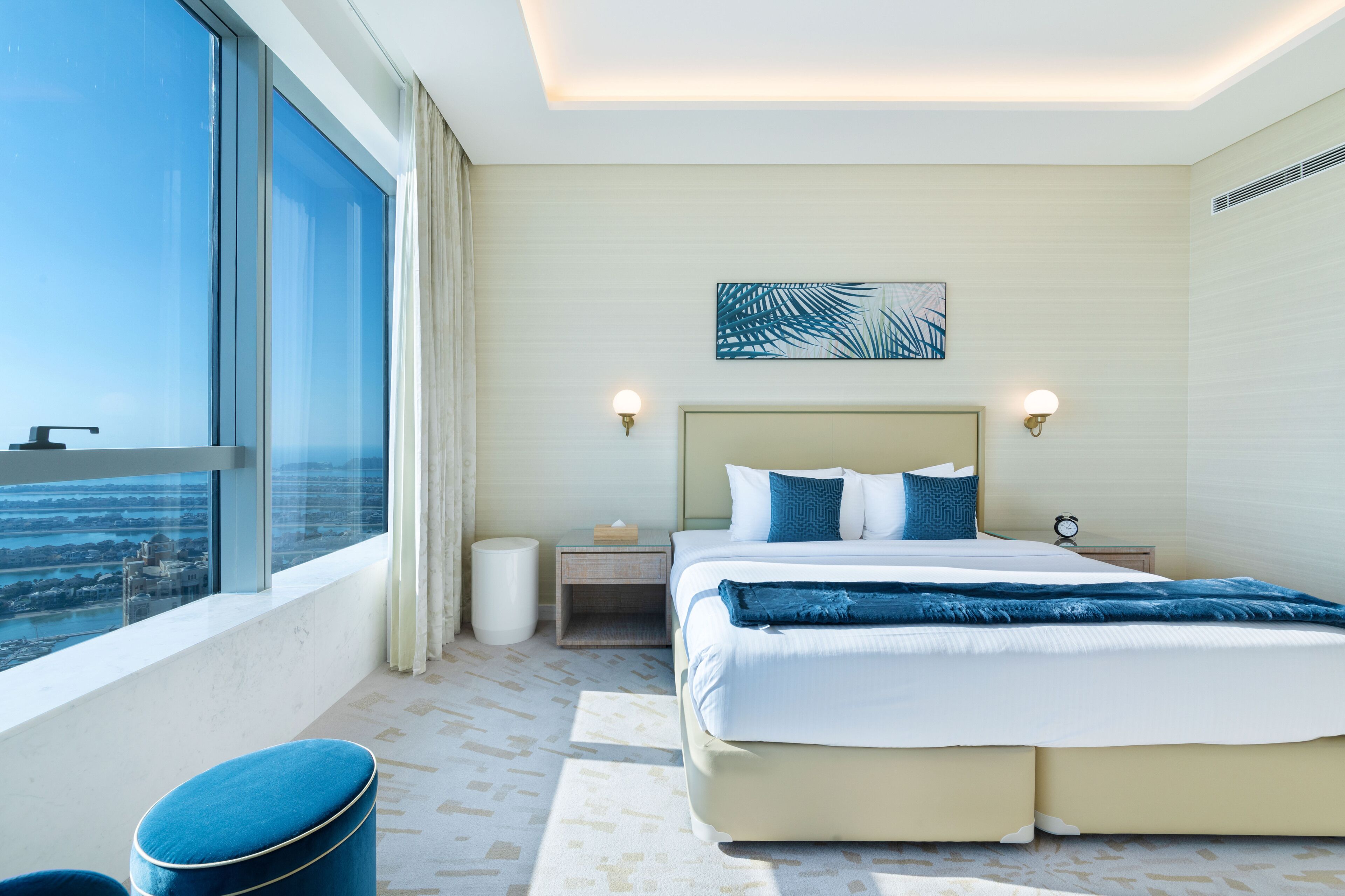 Une chambre d’hôtel moderne avec un grand lit, une vue sur la ville et un balcon.