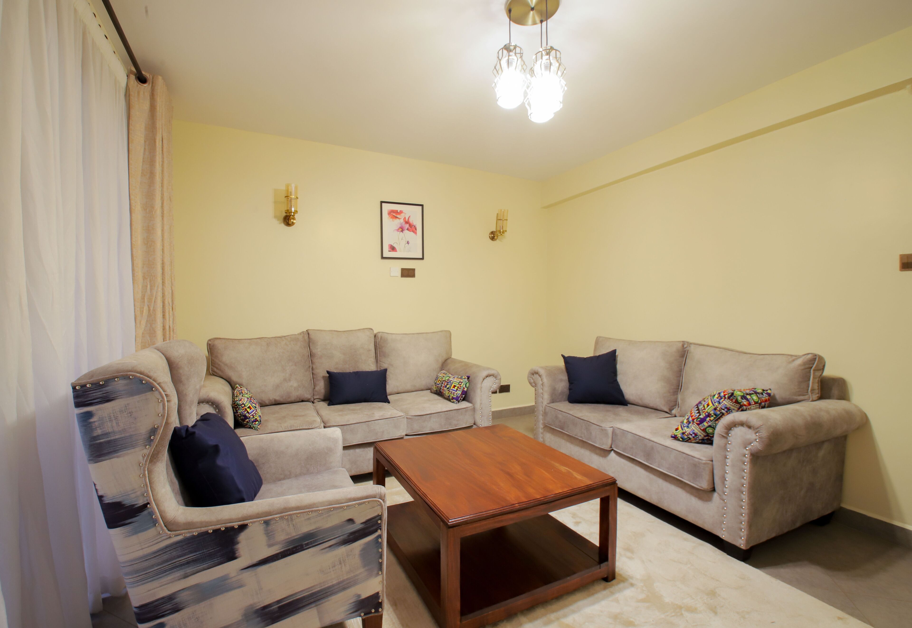 A living room with two sofas, a coffee table, and a chandelier.