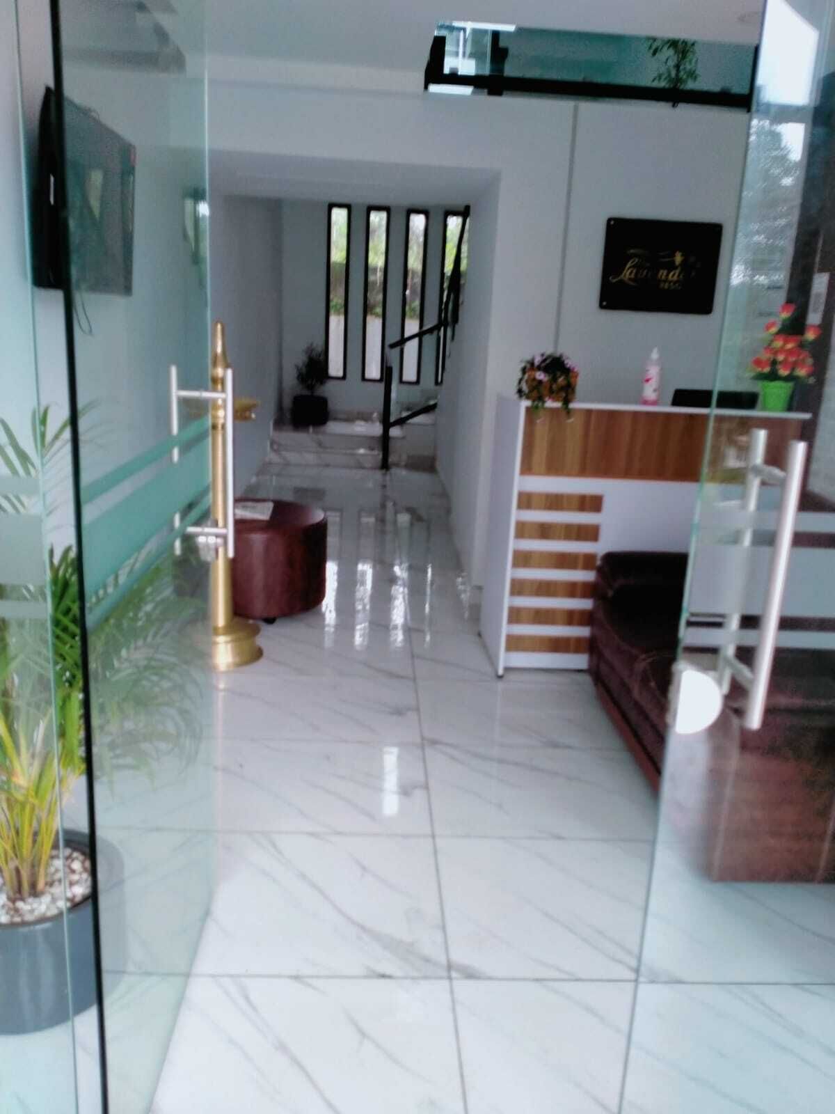 A modern interior with a reception desk, a staircase, and a seating area.