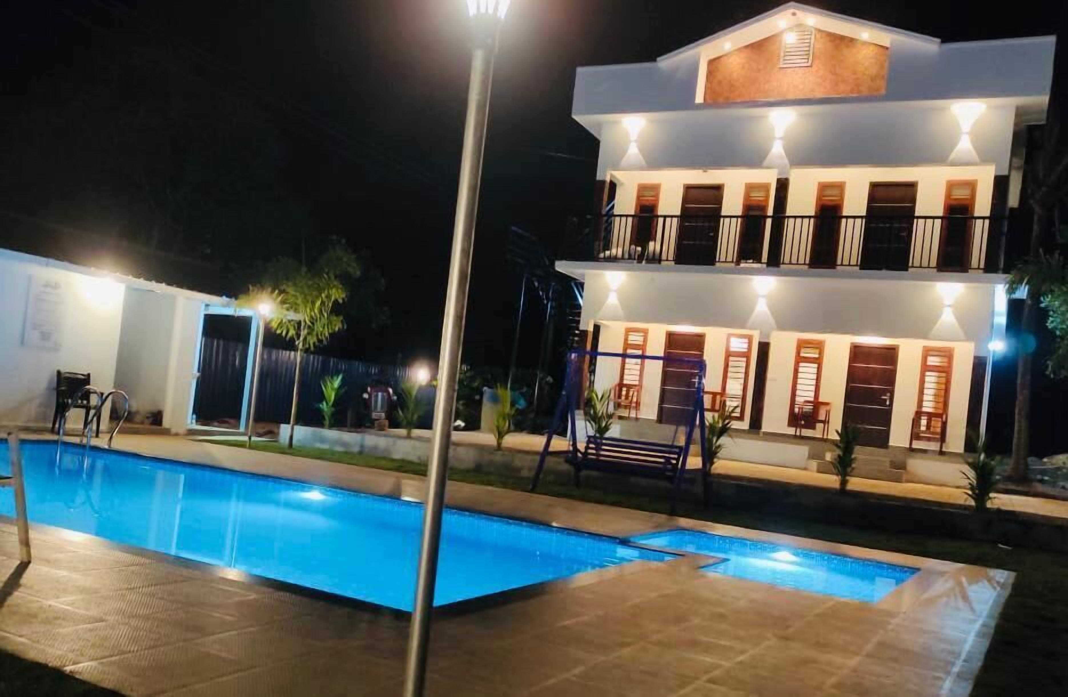 A two-story building with a swimming pool in the foreground.