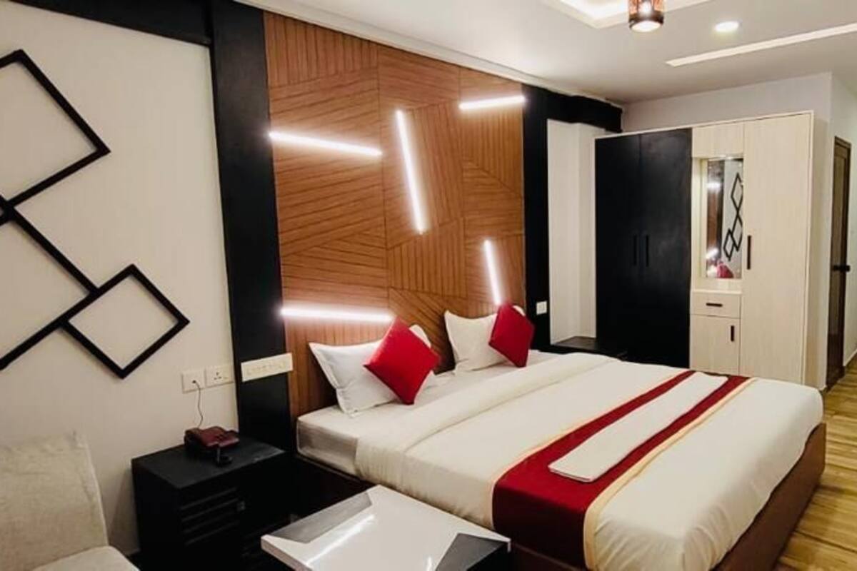 Ein modernes Hotelzimmer mit einem großen Bett, Nachttischen, einem Kleiderschrank und einem Fernseher.