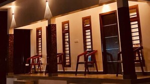 A multi-story building with balconies and exterior lighting. - The Lavender Resort (Vythiri)