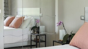 A bedroom with a bed, a nightstand, a lamp, and a mirror. - Villa in the heart of Tuscany (Rigutino)