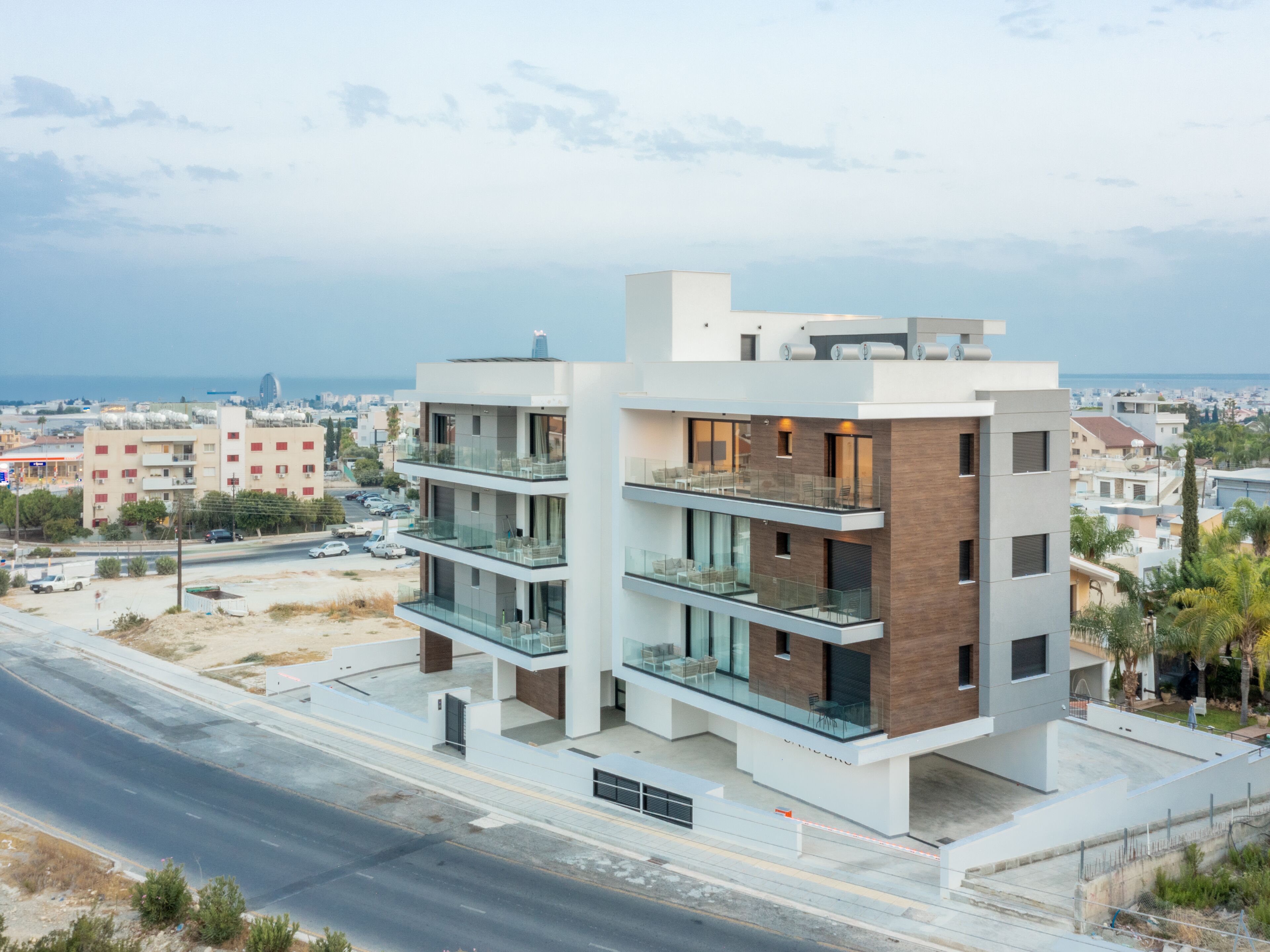 Un edificio moderno de varios pisos con balcones, grandes ventanales y vista al mar.