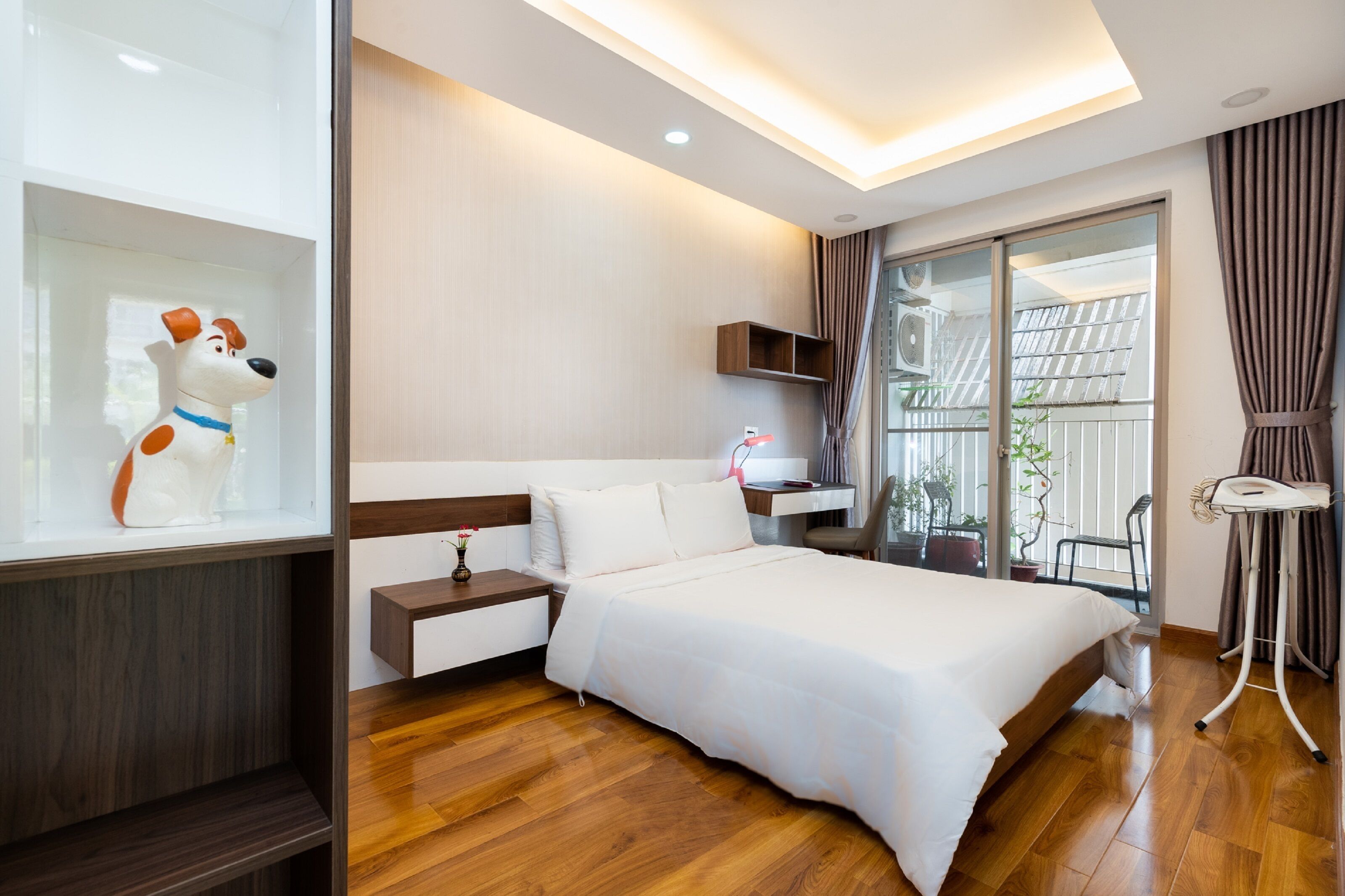 Une chambre d’hôtel moderne avec un grand lit, une table de chevet et une statue de chien décorative.