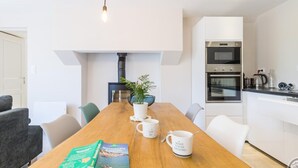A modern kitchen with white cabinets, a built-in oven, and a coffee maker.