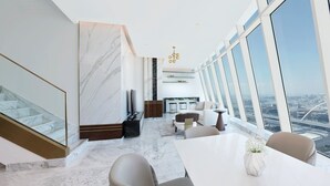 A modern interior with a dining area, large windows, and a city view. - Velero Hotel Doha Lusail (Doha)