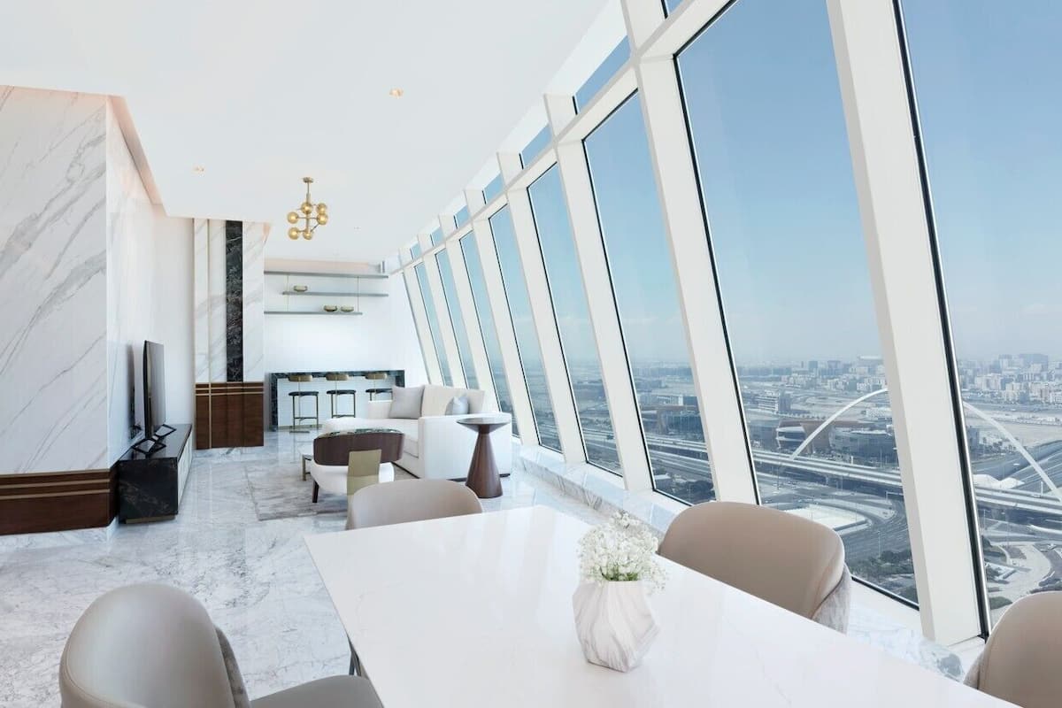 A modern interior with a dining area, large windows, and a city view.