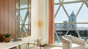 A modern room with a large window, a desk, a chair, and a sofa. - Velero Hotel Doha Lusail (Doha)