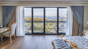Um quarto espaçoso com uma varanda ampla, móveis requintados e vista para a cidade.