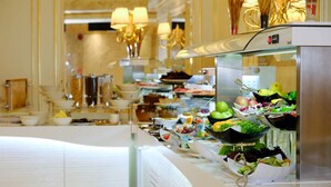 Buffet com diversos alimentos e uma vitrine de vidro.