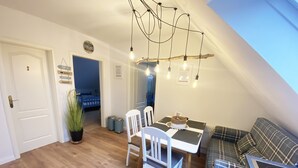 Una habitación acogedora con una mesa de comedor, sillas, un sofá y una kitchenette.