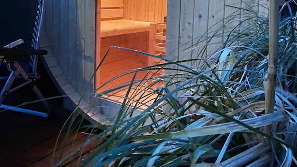Estructura de madera con un letrero que dice "HOME DELUXE" y un interior visible con una escalera.