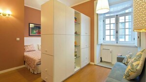 A bedroom with a bed, a wardrobe, a window with a view, and a sofa. - PORTO CLÉRIGOS Apartments Daisy (1st) (Porto)