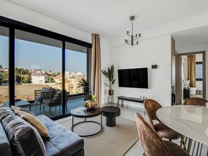 Un salon moderne avec un canapé, une table à manger et un téléviseur.