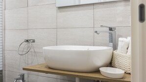 A bathroom with a large white sink, a wooden countertop, a towel rack, and a mirror. - AdAstra b&b (Naples)
