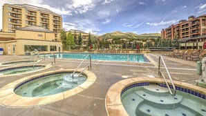 Un hôtel doté de plusieurs piscines, de chaises longues et offrant une vue imprenable sur les montagnes.
