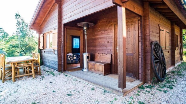 A wooden cabin with a porch, a bench, and a table. - 2 bedroom private vacation home in figueirã³ dos vinhos (Figueiró dos Vinhos)