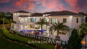A modern two-story house with a swimming pool, surrounded by palm trees and a well-maintained lawn. - Grandhalla - the Pinnacle of Luxury in Orlando (Kissimmee)