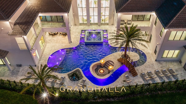 A modern house with a swimming pool, outdoor seating, and a well-lit entrance. - Grandhalla - the Pinnacle of Luxury in Orlando (Kissimmee)
