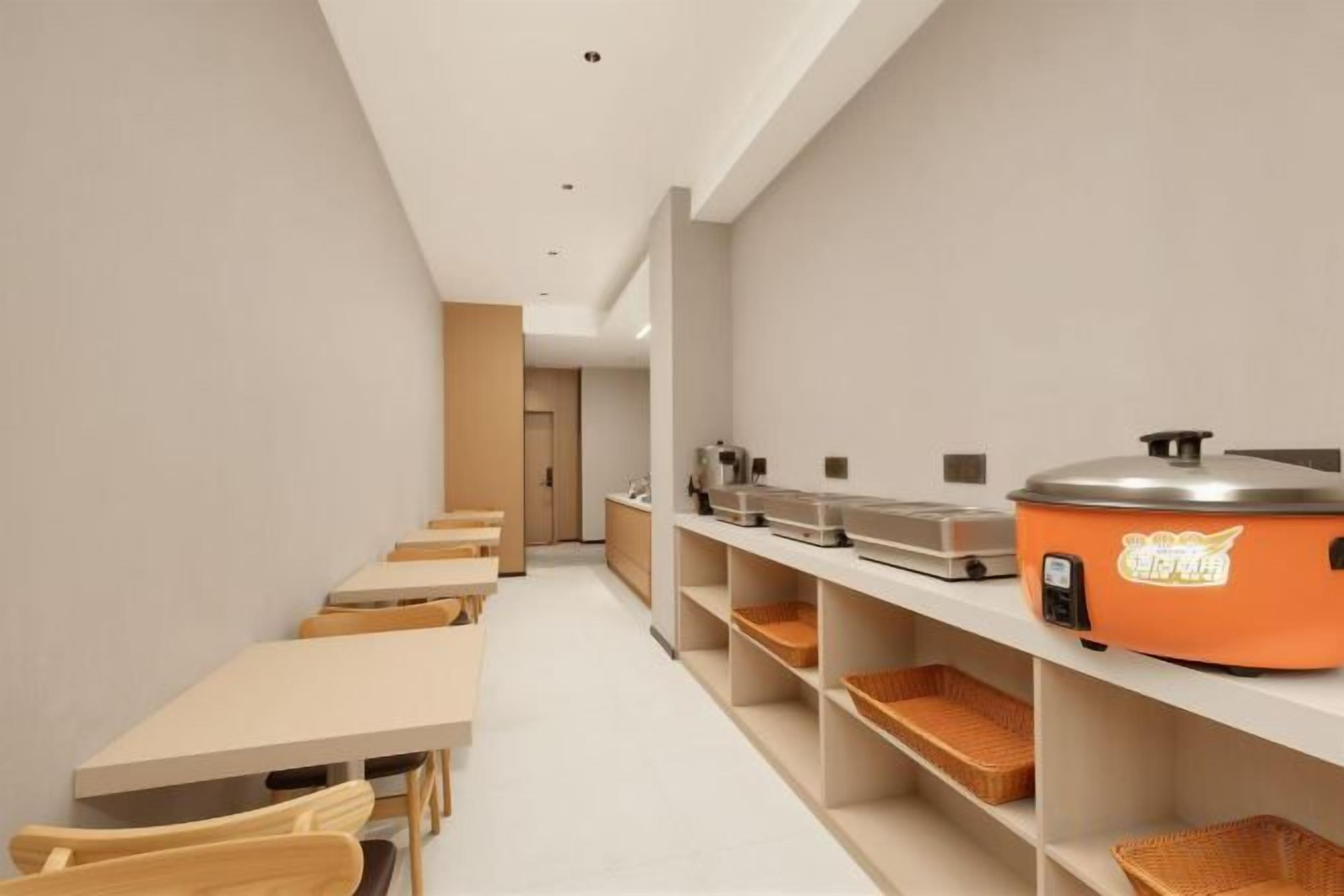Een moderne keuken met een lange toonbank, een koffieapparaat en opbergplanken.