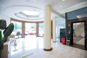 A hotel lobby with a skylight, a reception desk, and a large pillar. - Wenhua Hotel (Zhuhai)