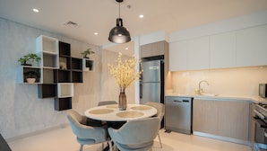 Een moderne keuken met een ronde eettafel, inbouwplanken en een centrale vaas.