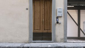 A wooden door with a metal frame, a small sign above it, and a keypad lock on the right. - Numa Florence Fiore (Florence)