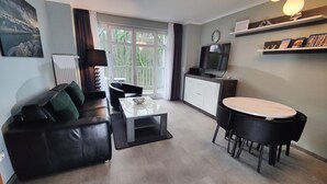 Un salon moderne avec un canapé, une table basse et un coin repas.