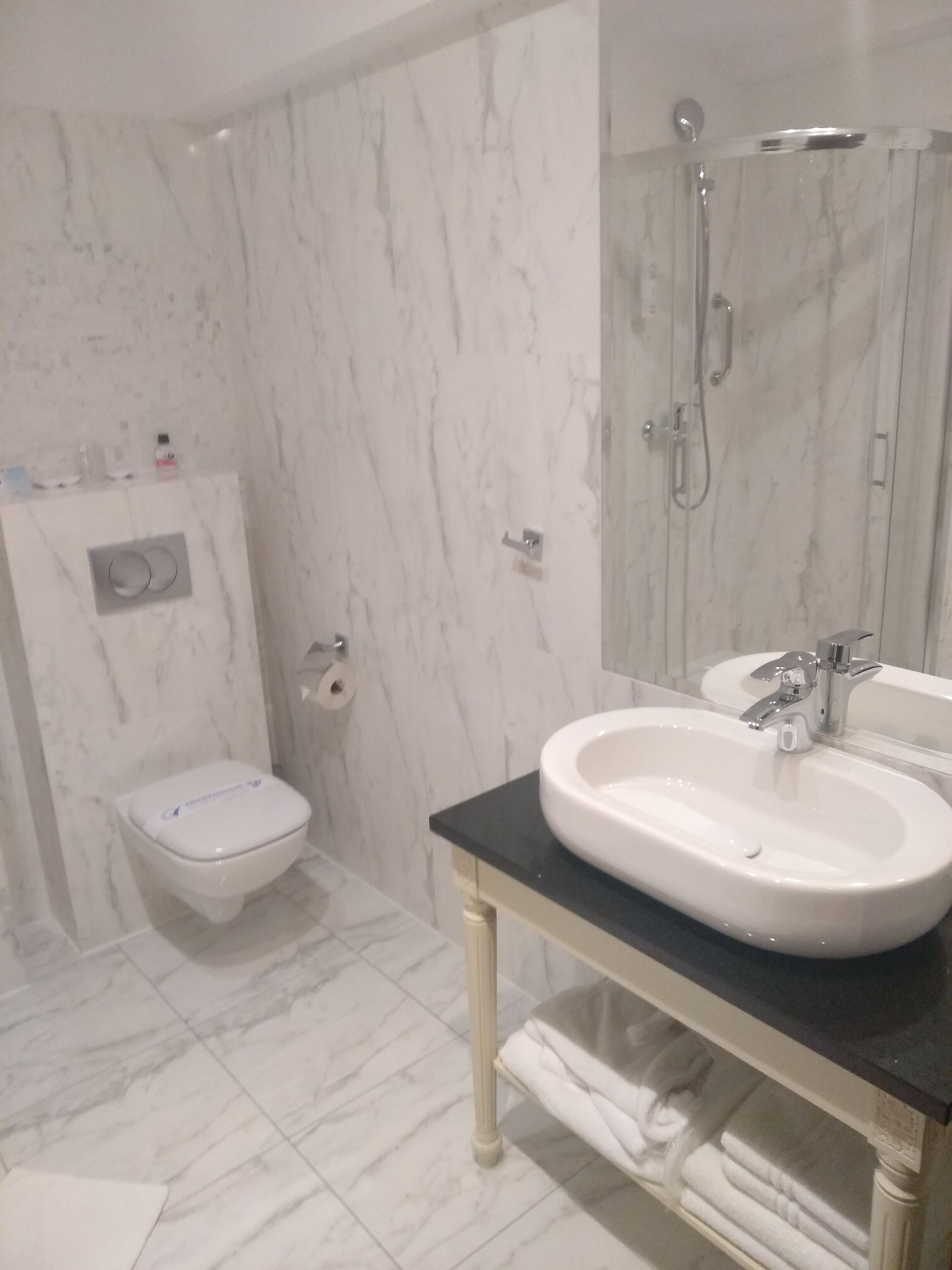 Une salle de bain comprenant des toilettes, un bidet, un lavabo et une douche.