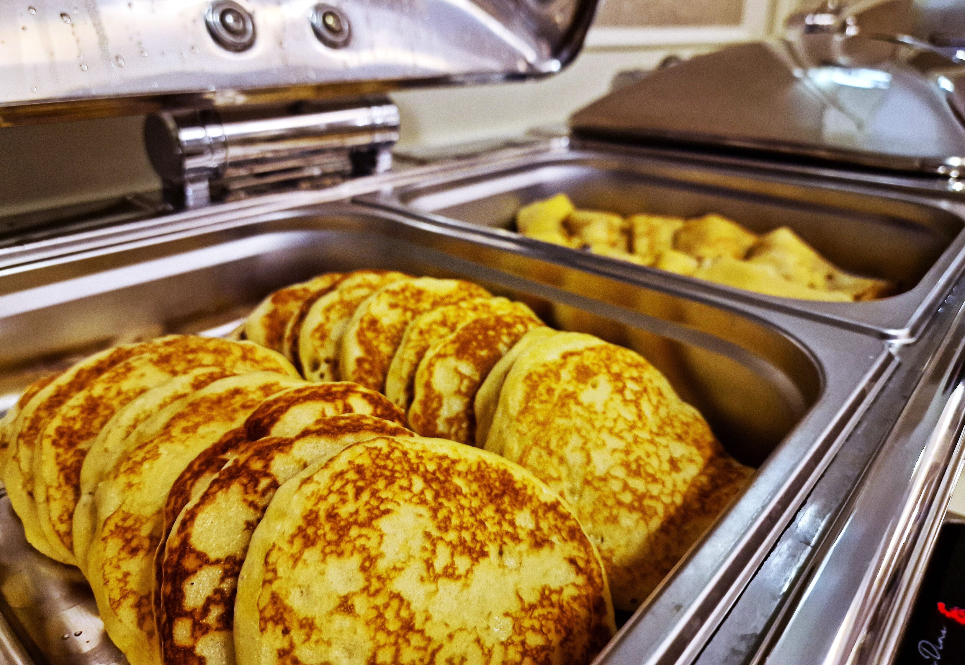 Een buffet met pannenkoeken en andere ontbijtartikelen.