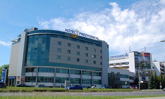 Un hotel moderno con fachada curva, varios pisos y un cartel llamativo.