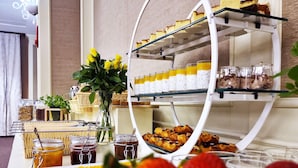 Una mesa de buffet con diversos alimentos, como pasteles, frutas y salsas.